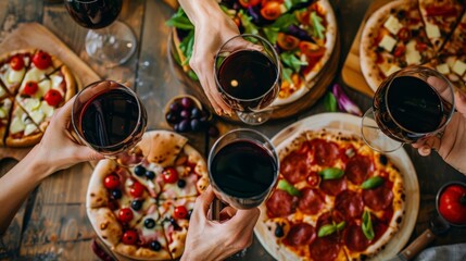 Hands reach for glasses of red wine and slices of pizza