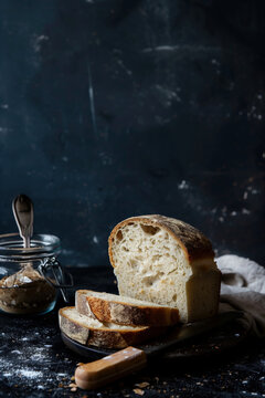Artisan bread slices on dark rustic background. Generative AI image