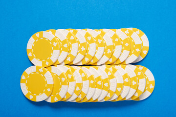 Yellow casino chips on a blue surface