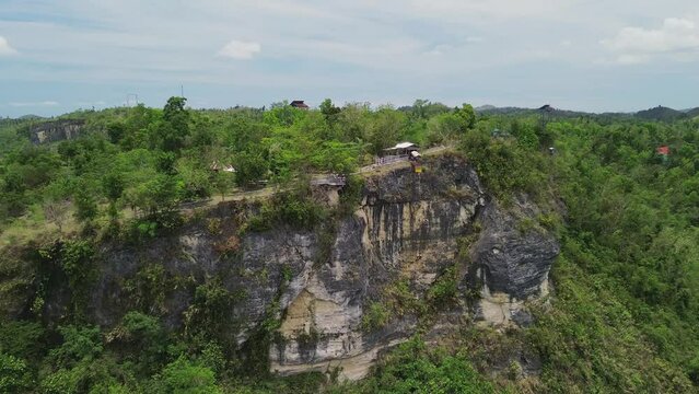 Drone view of a person doing bungee jumping from the cliff of the mountain in Danao Bohol, Philippines. With the mountainous view over the top of the mountains.