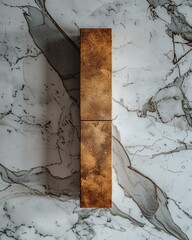 A vertical photograph showcasing a single, tall, rectangular, golden bar placed against a contrasting backdrop of white marble with grey veins.