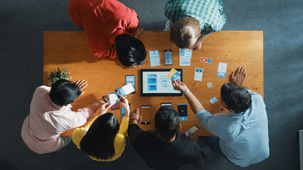 Top view of software developer team looking Ux Ui design for mobile phone interface from tablet...