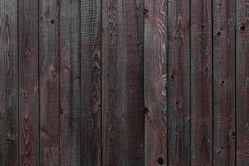 Naklejka premium abstract background of old wooden fence painted burgundy close up