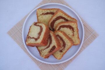 sponge cake on a plate on the white background, top view
