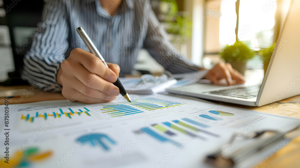 Aufkleber person analyzing business charts and graphs at a desk using a pen and laptop, focusing on financial 