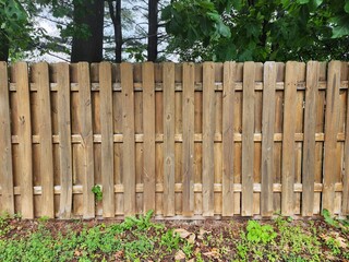 Wooden fence with alternating panels. Privacy fence in backyard.