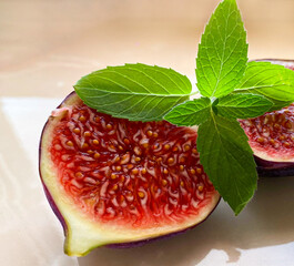 ripe juicy figs with fresh mint leaves on a marble table