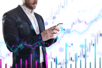 A businessman using a smartphone with financial charts overlaid in the background, representing analytics and technology