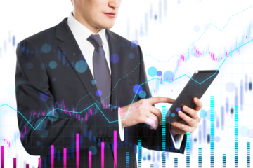 A businessman using a tablet with financial charts overlaid in the background, representing analytics and technology