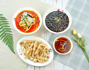식탁 위에 짜장면, 탕수육, 짬뽕이 놓여 있는 모습