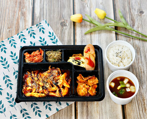 오징어 볶음 도시락이 식탁 위에 놓여 있는 모습