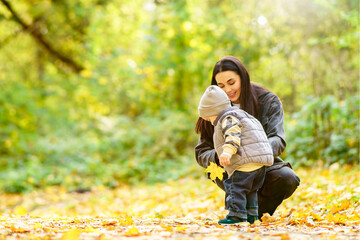 Mother and son playing in autumn leaves