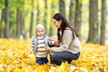 Mother and son walking through fall leaves