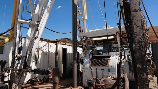 Footage at the rig producing oil or gas. Working equipment drilling the ground for natural resources extraction.