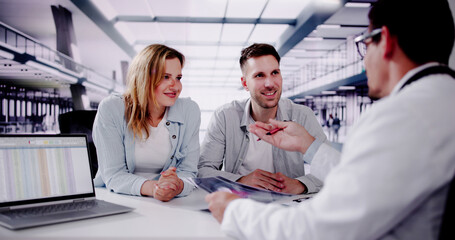 Fototapeta premium Smiling Doctor Explaining Pregnancy Test Results to Expectant Couple