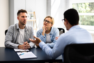 Financial consultant explaining new project investment to young couple in office