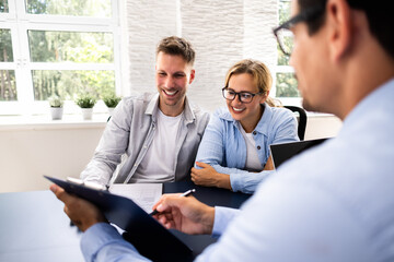 Financial consultant explaining new project investment to young couple in office