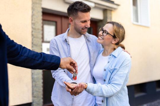Real estate agent handing over keys to a young couple for their new home