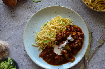 family meal background, served food, beef perkelt, spaetzle, blue plate, top view