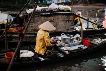 A Vietnamese woman selling pho on the Phong Dien floating market in Vietnam
