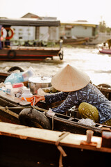 A Vietnamese woman selling drinks on the Cai Rang floating market in Vietnam