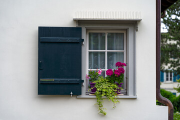 Window with flower decoration and wooden shutter of traditional house at Swiss City of Z&uuml;rich. Photo taken July 6th, 2024, Zurich, Switzerland.