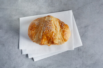 A top down view of a croissant with sesame seeds.