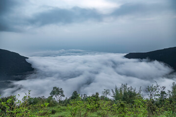 mountain range valley filled with low clouds with dramatic sky at morning image is taken at nongriat cherrapunjee meghalaya india.