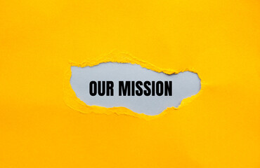 Our mission message written on ripped yellow torn paper with gray background. Conceptual our...