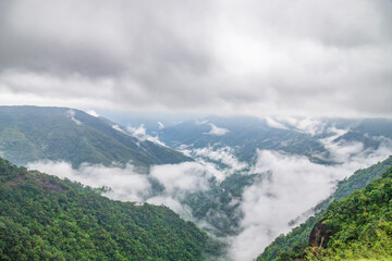 mountain range valley filled with low clouds with dramatic sky at morning image is taken at wah-kaba falls cherrapunjee meghalaya india.