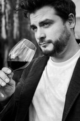 Hombre apuesto tomando una copa de vino. Fotografía en blanco y negro