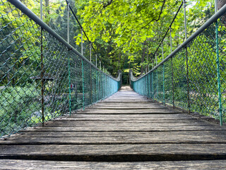 Obraz premium empty suspension bridge in the forest, hiking concept