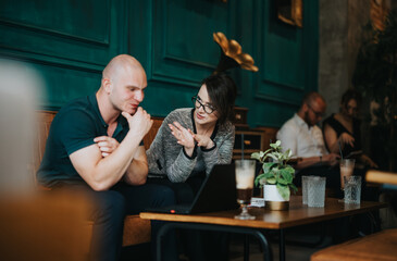 Two business professionals having a focused meeting and discussion in a modern cafe. Teamwork, strategy, and growth concepts are evident.