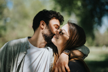 A happy, carefree couple enjoys a joyful moment embracing outdoors in a sunny urban park during their free time on a weekend.