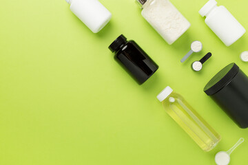 Fototapeta premium Jars with protein powder on color background, top view. Sports nutrition concept