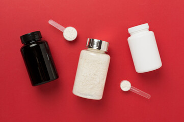 Jars with protein powder on color background, top view. Sports nutrition concept