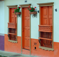 Detail of wooden multi-colored carved windows and a door. Jardin, Jardín, Antioquia, Colombia.