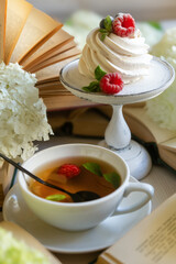 Tea in a beautiful white cup, cake with berries and white hydrangea flowers.