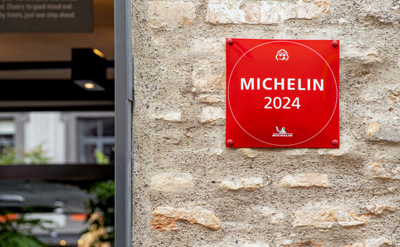 Michelin Guide sign for restaurant excellence hanging on brick wall