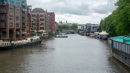 View from Bristol Bridge, A view from Bristol Bridge in Bristol, UK, overlooking the waterfront with moored boats and surrounding buildings under a cloudy sky