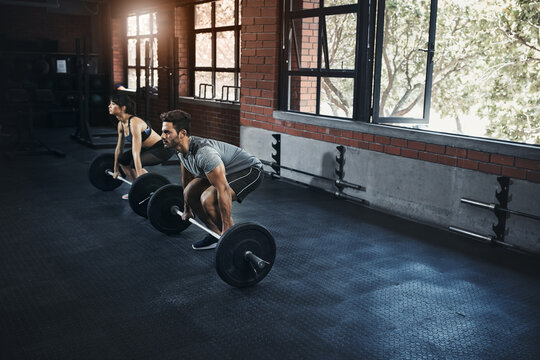 Deadlift, couple and training with barbell in gym for muscle, wellness and healthy body. Fitness, man and strong woman weightlifting for power, bodybuilding and workout together to exercise at club
