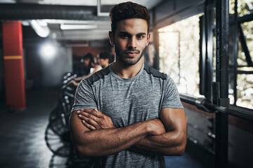 Man, portrait and confident in gym for fitness, bodybuilding and personal training for health or muscle strength. Male person, arms crossed and proud for active living, exercise and cardio workout.