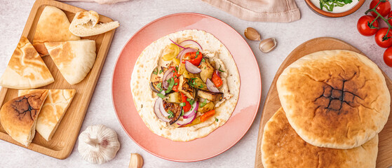 Tasty pita bread with grilled vegetables, hummus and sauce on white background