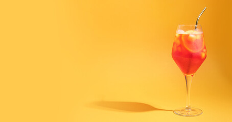 Glass of Aperol spritz cocktail on color background