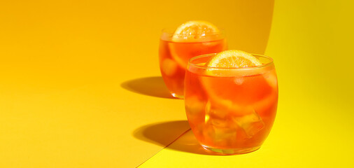 Glasses of Aperol spritz cocktail on color background