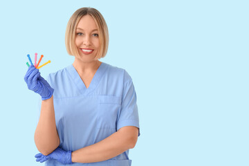 Female orthodontist with ligatures on blue background