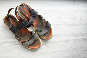 Prevent and remove mould from leather shoes. Summer shoes with abundant mould on a light wood background, top view, with space for text. mould from leather shoes. ill-fitting shoes