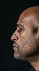 Obraz premium A man's profile, showing his face and neck, against a dark background