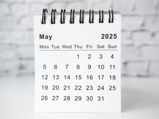 May 2025 white monthly desk calendar on a table
