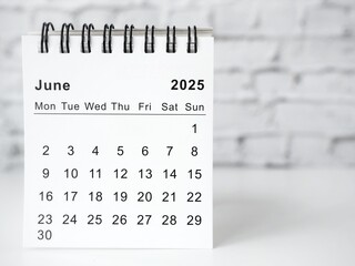 June 2025 white monthly desk calendar on a table